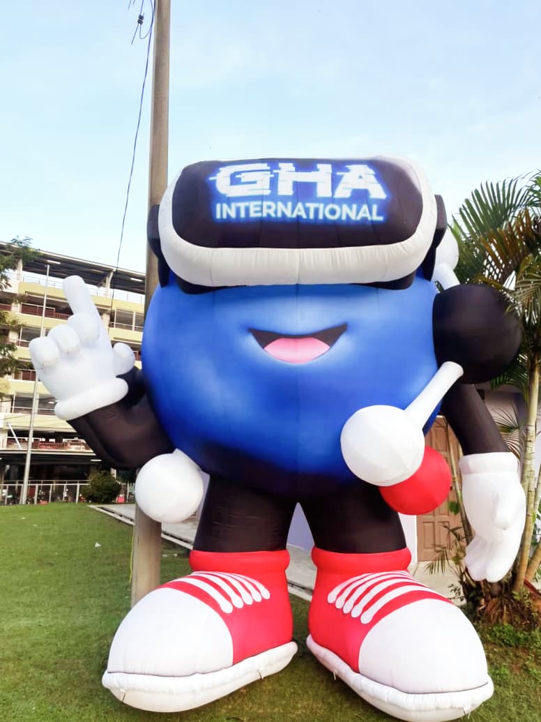 The GHA International mascot standing on a school field